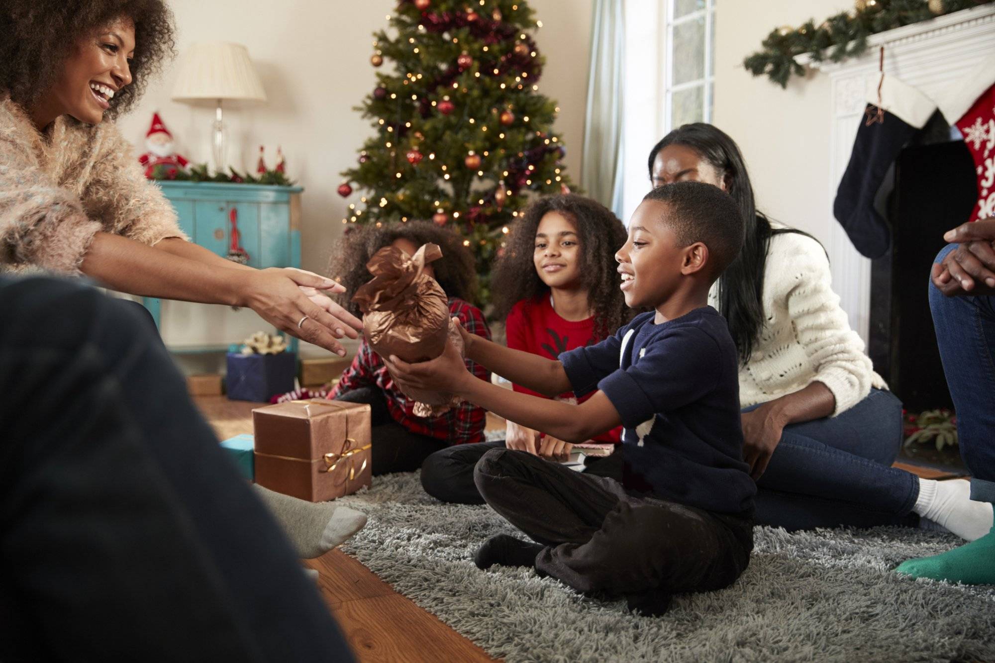 Son Giving Mother Gift As Multi Generation Family Celebrate Christmas At Home Together